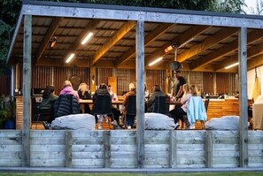 An outdoor wooden structure with a covered seating area and a bar.
