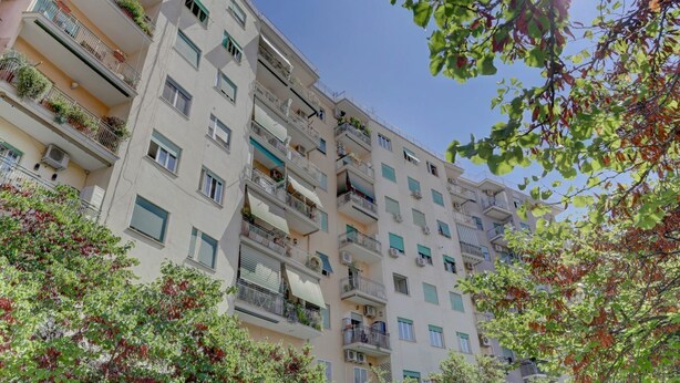 A multi-story residential building with balconies, air conditioning units, and windows with shutters. - Furio Camillo Studio - Metro A - Netflix (Roma)