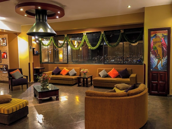 A modern lobby with a sofa set, a coffee table, and a wooden accent chair.