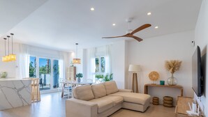 A spacious living area with a modern sofa, a dining table with chairs, a ceiling fan, and a TV mounted on the wall. - Ref. 503105 (Motril)