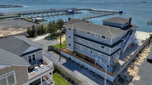 A multi-story building with a balcony, adjacent to a marina with docks extending into the water.