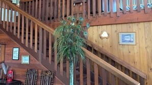Una escalera de madera con un arreglo de plumas de pavo real sobre una mesa.