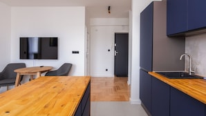 Una cocina moderna con armarios oscuros, una encimera de madera y un lavamanos empotrado.