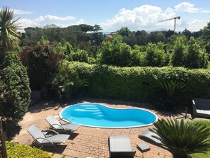 A swimming pool surrounded by lounge chairs and a hedge. -  L'affittacamere nel parco "Appia Antica" (Rome)