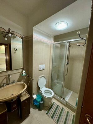 A bathroom with a sink, toilet, and shower.