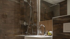 A modern bathroom with a glass-enclosed shower, a white sink, and a toilet. - Sportalm Seefeld - Apartment with breakfast included (Seefeld in Tirol)