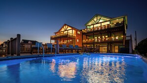 Um hotel de dois andares com uma piscina em primeiro plano.