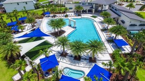 A resort with a central swimming pool, multiple lounge areas, and a view of surrounding residential buildings. - Themed Theater Room | Themed Kids Bedrooms | Games Area | Screened Pool (Kissimmee)