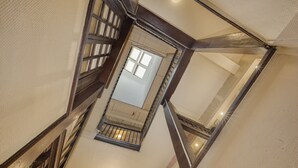 A high-ceilinged staircase with wooden railings and a skylight.