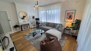 Een moderne woonkamer met een bank, salontafel en een open haard.