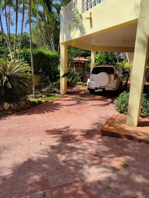 Stroll through lush tropical surroundings to a covered entrance area.