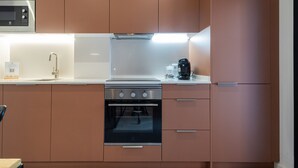 Une cuisine moderne équipée d’appareils électroménagers en acier inoxydable, d’un four à micro-ondes, d’une machine à café et d’un évier.