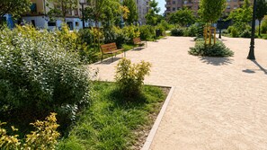 Un parc avec des bancs, des allées et de la verdure.
