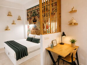 Une chambre à coucher comprenant un lit, un bureau avec une chaise et des éléments décoratifs sur les murs.