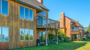 A wooden house with a balcony and large windows.