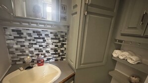 Un baño pequeño con un lavabo blanco, un inodoro y un salpicadero de azulejos.