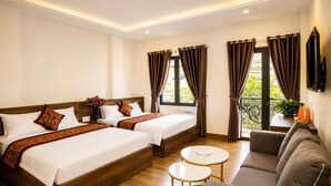 A hotel room with two beds, a sofa, a small table, and a TV. - Lien's Hotel Da Lat (Xuan Huong - Da Lat)