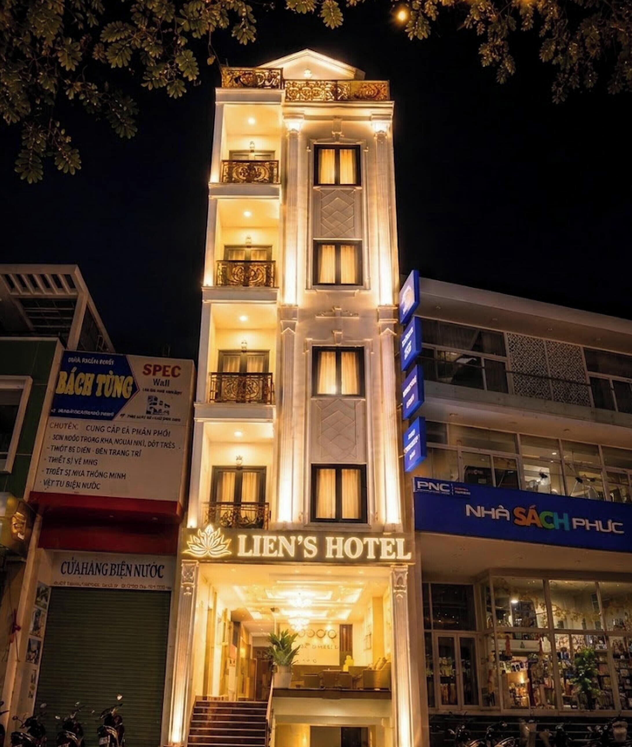 Ein mehrstöckiges Hotel mit beleuchteter Beschilderung, Balkonen und einem gut sichtbaren Eingang.