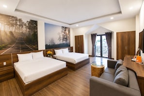 Une chambre d’hôtel avec deux lits, un canapé, une table basse, une télévision et une grande fenêtre avec des rideaux.