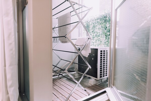 A laundry area with a drying rack and an air conditioning unit. - Minimalist Loft 202 (Osaka)