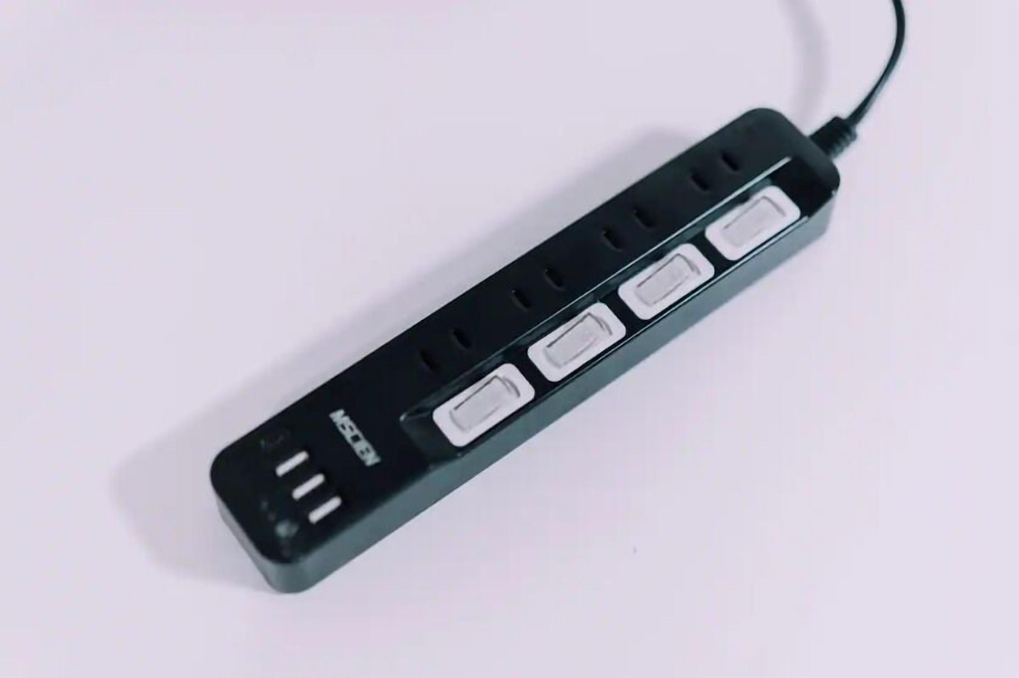 A black power strip with multiple USB ports and a standard electrical outlet.