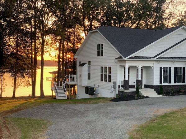 A two-story house with a covered porch and a staircase leading to a deck.