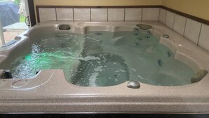 Ein Whirlpool mit mehreren Düsen, einer integrierten Sitzgelegenheit und einem Fenster für natürliches Licht.