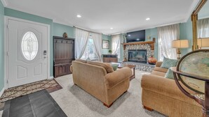 A living room with a fireplace, a sofa set, and a globe on a side table.