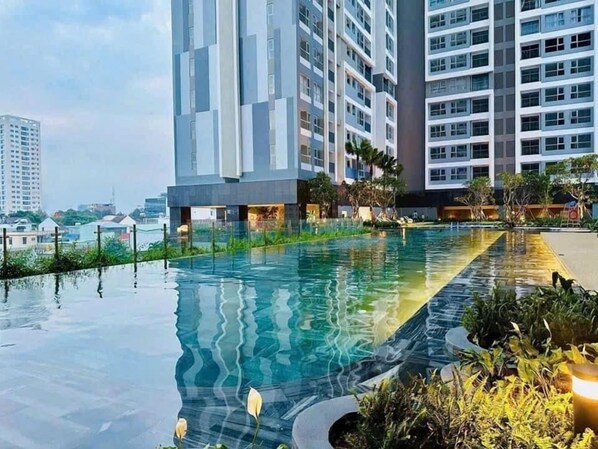 Una piscina al aire libre, sombrillas, tumbonas
