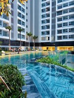 Una piscina al aire libre, sombrillas, tumbonas