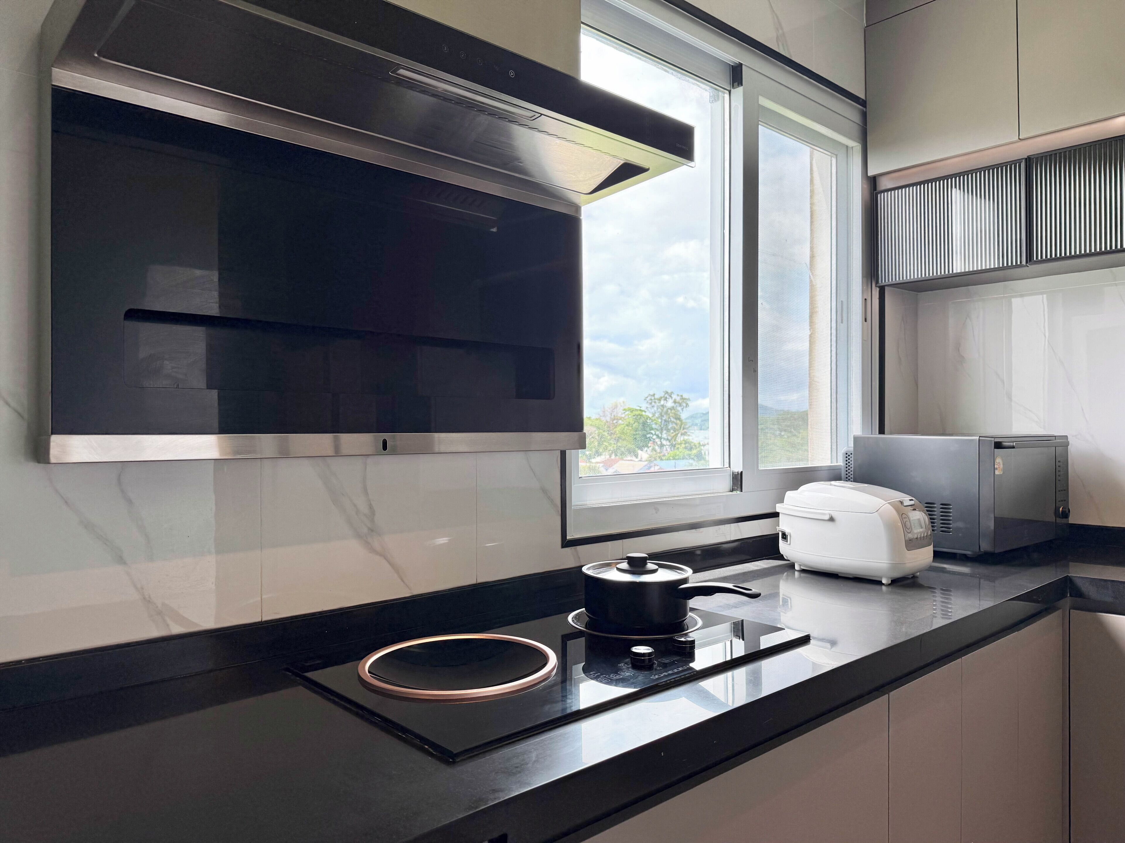 Una cocina moderna con horno empotrado, placa de cocción y ventana.