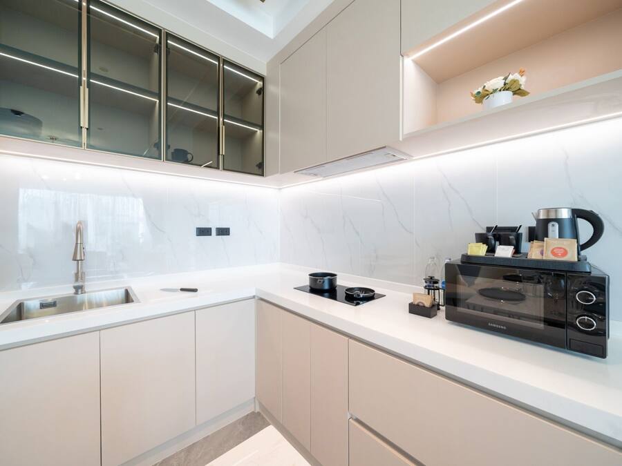 Una cocina moderna con microondas integrado, cafetera y lavamanos.