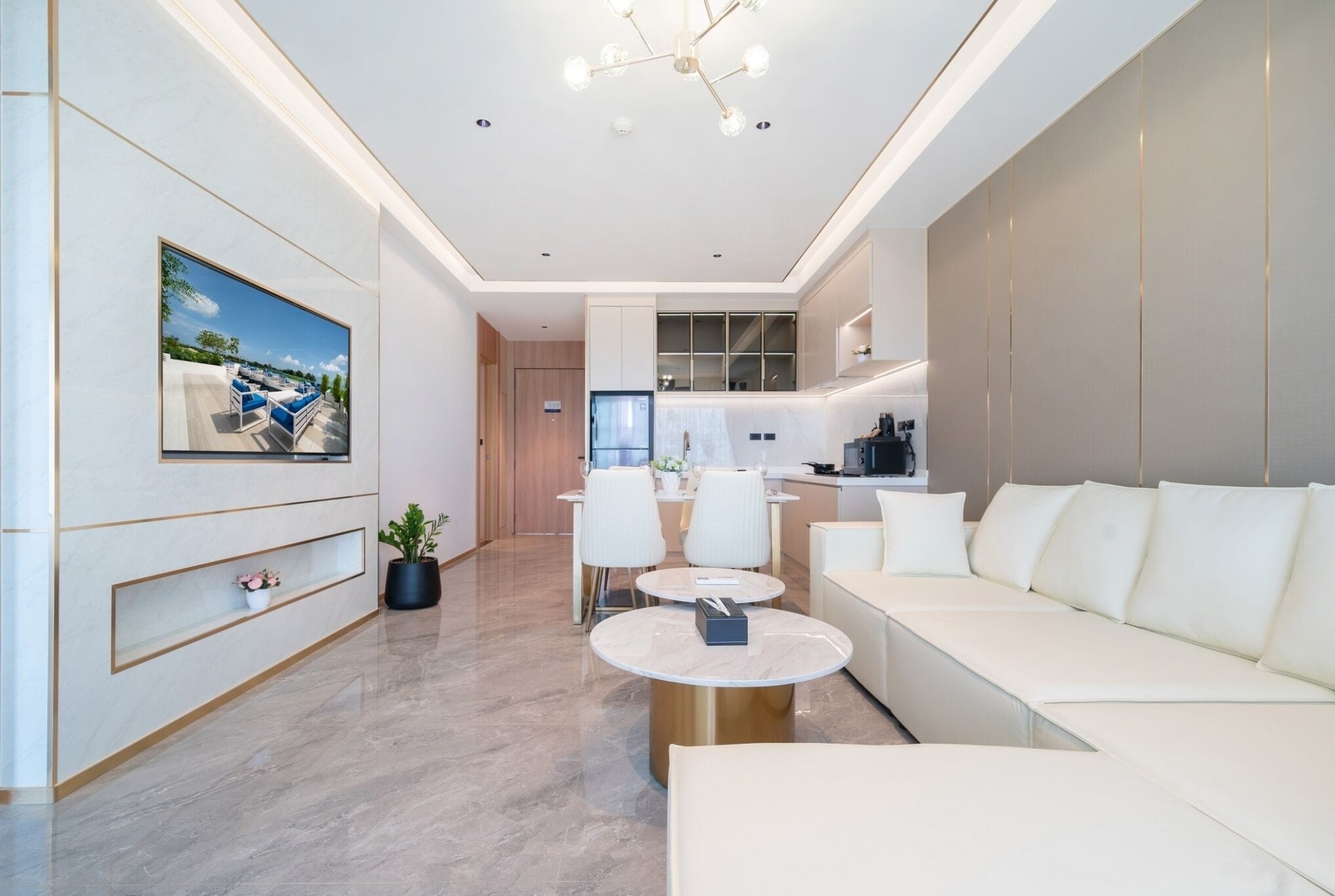 A modern living room with a sofa, a dining table, and a kitchen area in the background.