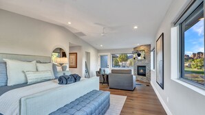 A modern bedroom with a large bed, a seating area, and a fireplace.