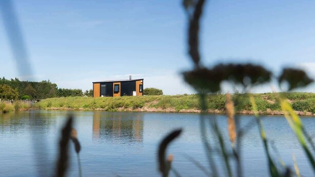 A modern house by a calm lake with a clear sky. - Vintners Retreat by Tiny Away (Burnham)