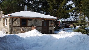 A stone building with a snow-covered roof, a wooden door, and a window. - Holiday Home 'Zum Pferdestall' with Shared Pool, Shared Terrace and Wi-Fi (Dreetz)