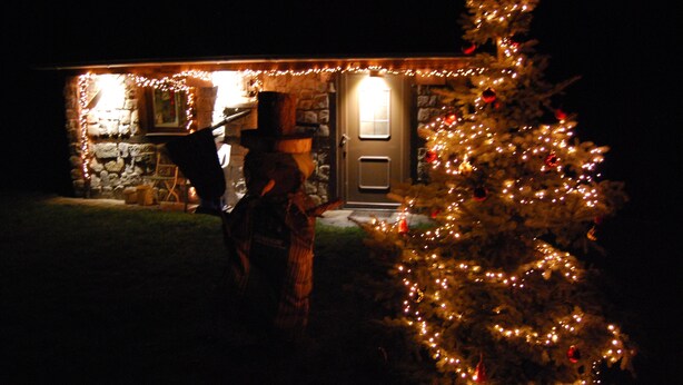 A house with a lit Christmas tree and a person standing in front. - Holiday Home 'Zum Pferdestall' with Shared Pool, Shared Terrace and Wi-Fi (Dreetz)