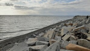 A rocky beach with large boulders and a person walking. - Apartment 'Meeresbucht' with Sea View, Private Terrace and Wi-Fi (Sassnitz)
