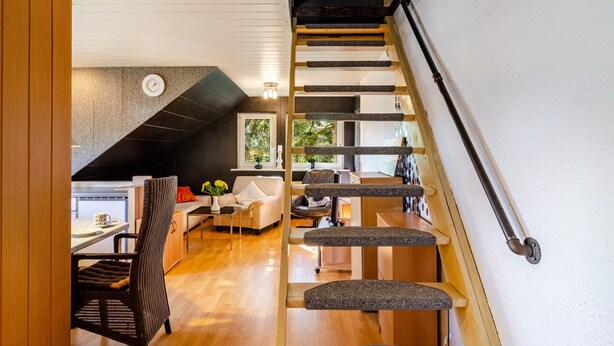 A modern interior with a staircase, a dining area, and a living space. - Apartment 'Ferienwohnung Klee 2' with Wi-Fi (WHV)