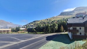 Un hotel con estacionamiento, zonas verdes y vistas a la montaña.