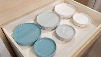 A drawer with neatly stacked plates in various colors.