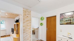 Una habitación moderna con un aparador de madera, un escritorio y una pintura de paisaje urbano.