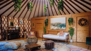 Un intérieur chaleureux avec un banc en bois, un canapé et un tapis à motifs.