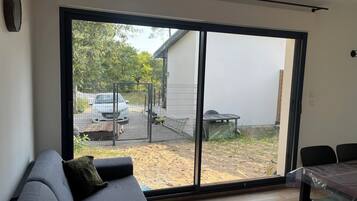 A room with a large sliding glass door leading to a backyard.