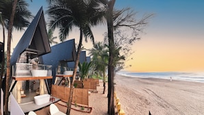 A beachside resort with a modern design, including a glass-walled infinity pool, lounge area, and a view of the ocean. - The Rose Goa Beach Resort (Canacona)