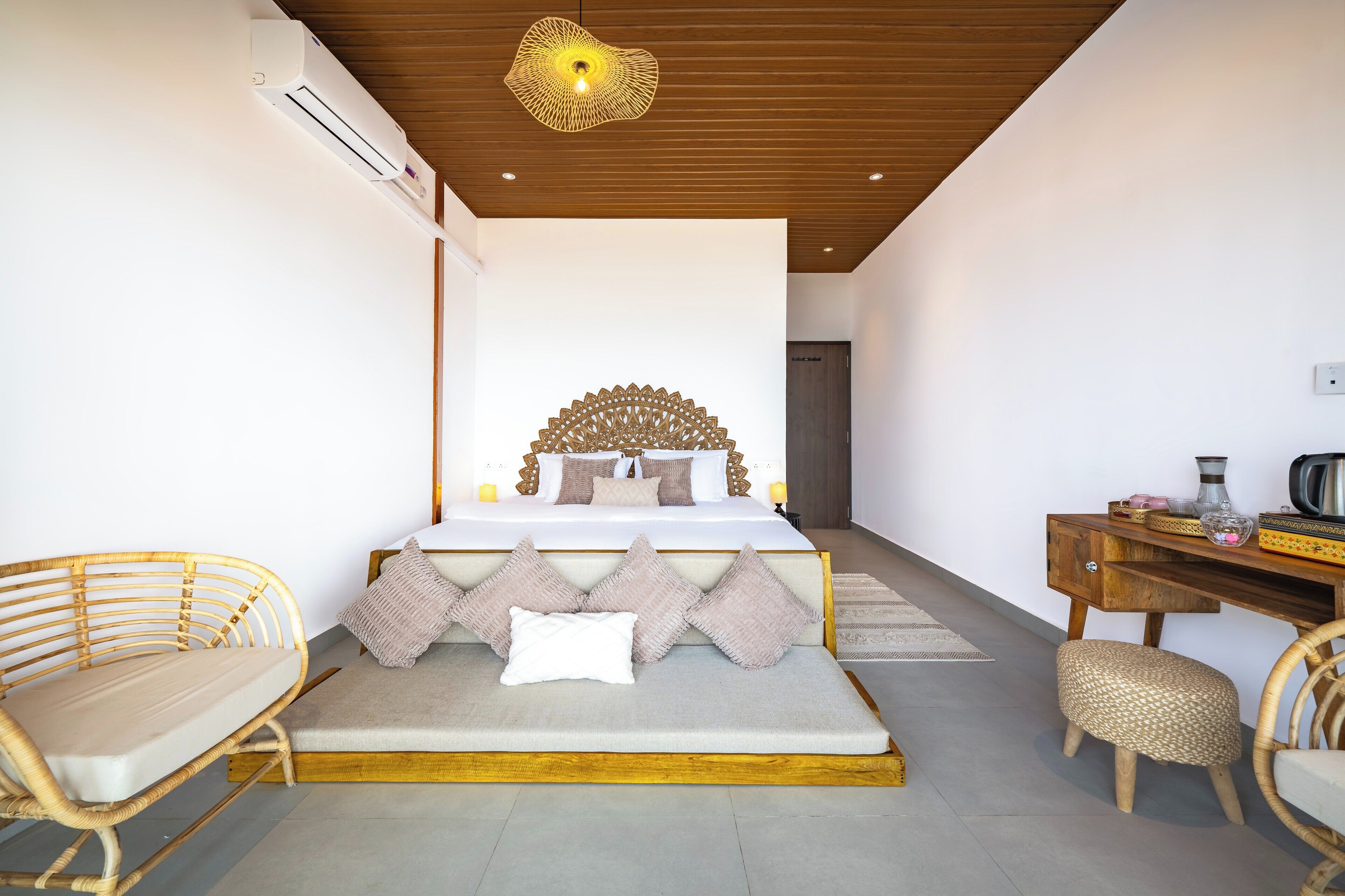 A bedroom with a bed, bedside tables, a desk, and a chair.