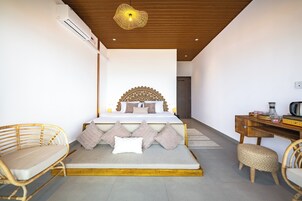 Un dormitorio con cama, mesitas de noche, un escritorio y una silla.