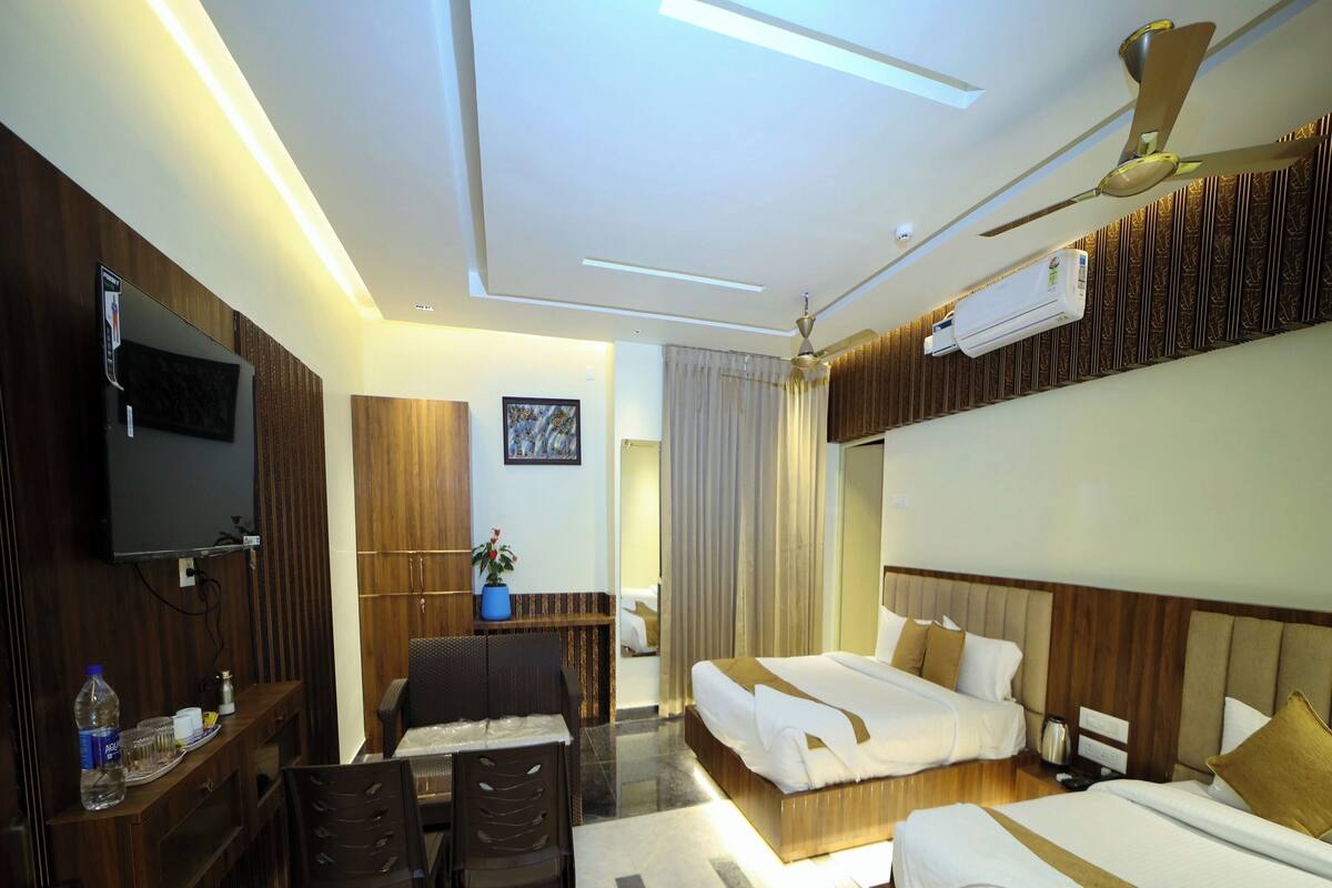 Une chambre d’hôtel équipée d’un lit, d’un bureau avec une chaise, d’une télévision et d’un ventilateur de plafond.