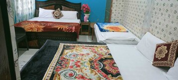 A room with two beds, a small table, and a chair.