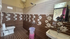 A bathroom with a toilet, sink, and shower. - Hotel Royal Sainik (Bhatwari)